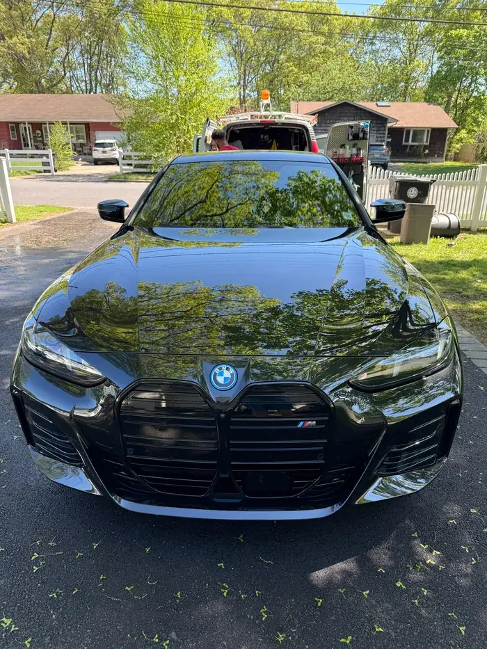 Freshly detailed black BMW with a glossy finish, parked in a driveway