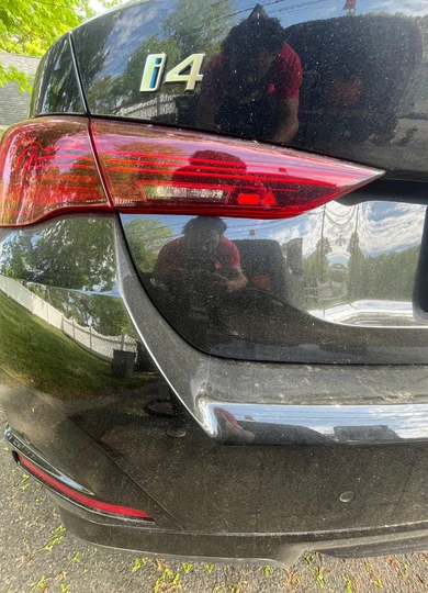 Close-up of a clean black BMW i4 taillight after detailing