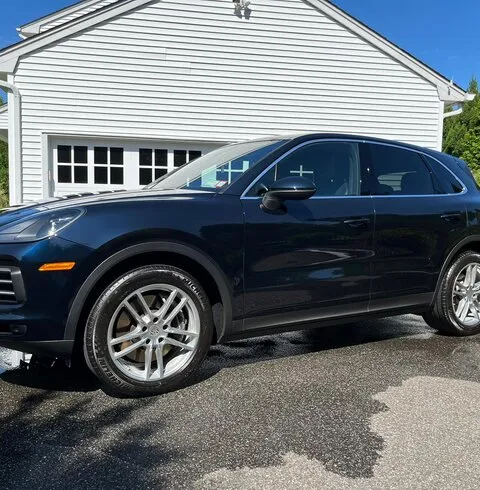 Clean dark blue Porsche Cayenne parked in a driveway after detailing
